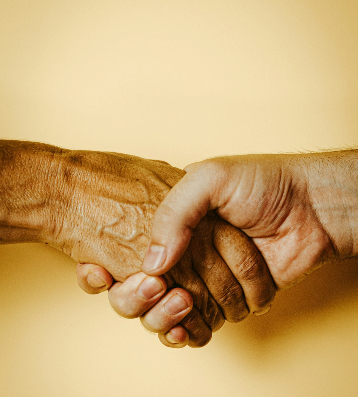 Two people holding hands, offering care and support